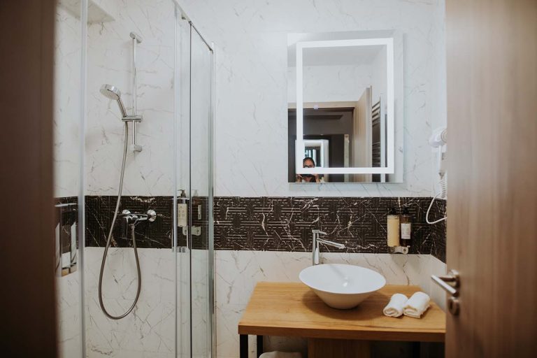 A bathroom with a sink and shower suitable for reservation in Sibiu.
