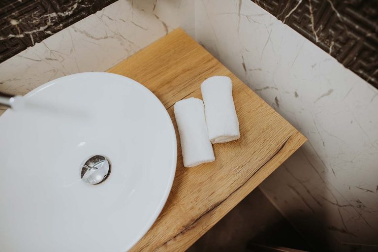 A bathroom with a wooden sink and white towels in Cisnadie.