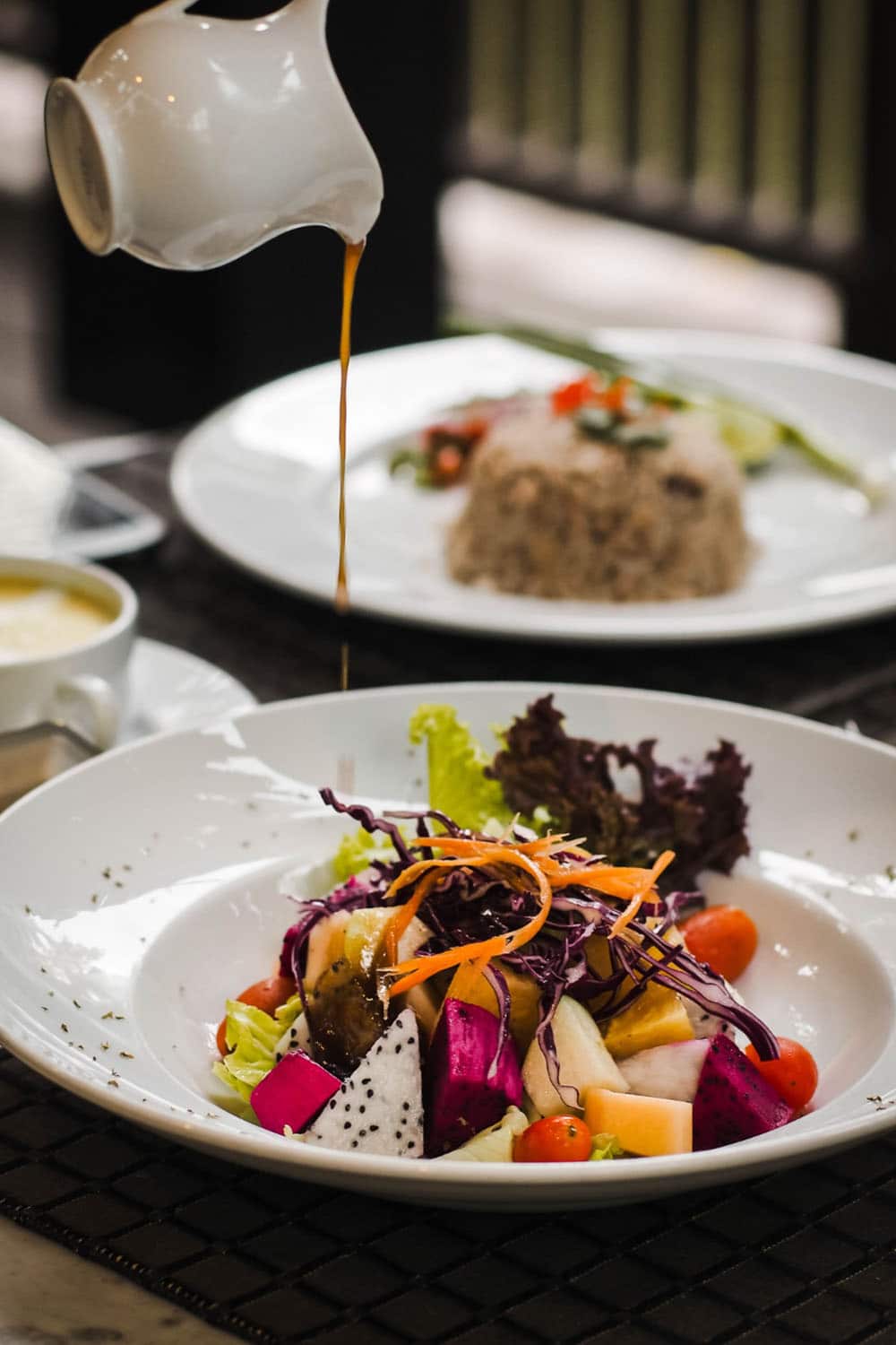 A plate of food with a sauce being poured over it at a hotel in Sibiu.