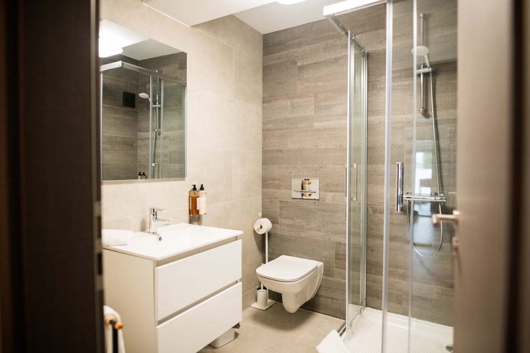A hotel bathroom in Sibiu with a toilet, sink and shower stall.