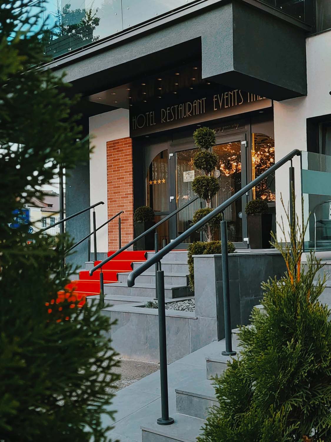 The entrance to a hotel in Cisnadie with a red carpet.
