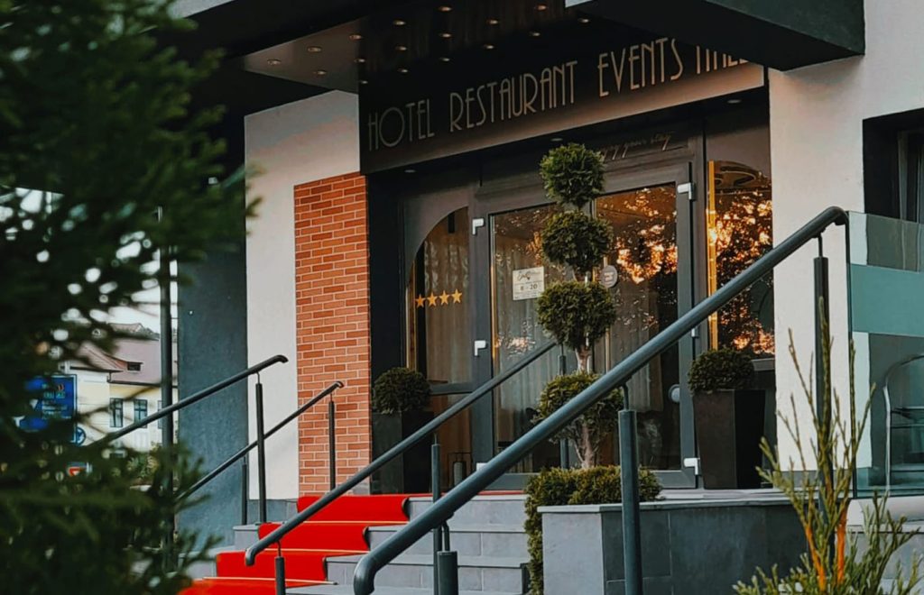 The entrance to a restaurant in Sibiu with a red carpet.