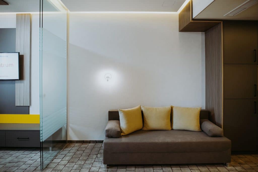 A hotel room with a couch and TV.