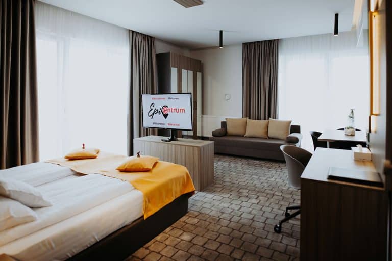 A hotel room in Sibiu with a bed, desk and TV.