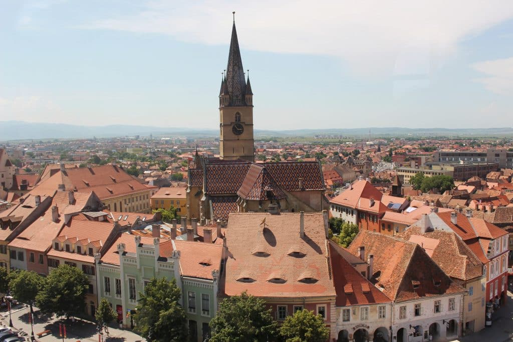 A view of a city from the top of a tower with hotel accommodations.