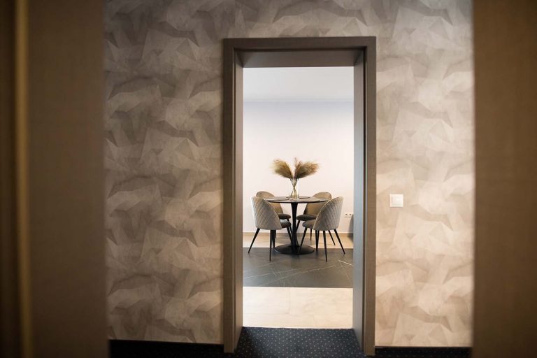 A hotel room with a table and chairs.