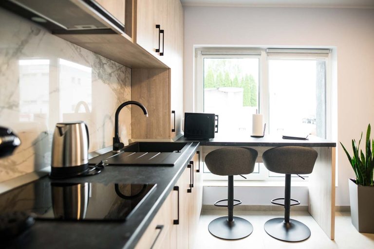 A hotel kitchen in Cisnadie with two stools and a sink available for reservation.