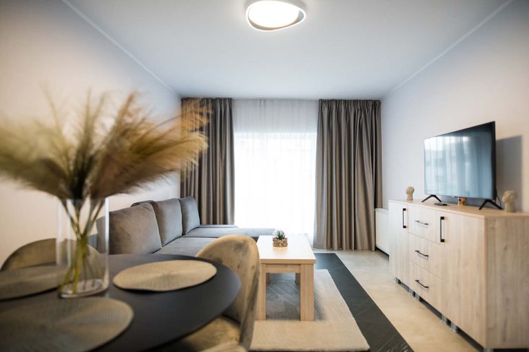 A living room with a table and chairs and a tv available for booking in Sibiu.