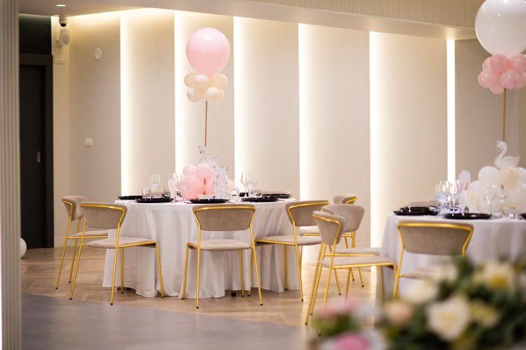 A sala de evenimente set up with pink and white balloons in an Epic Harmony theme.