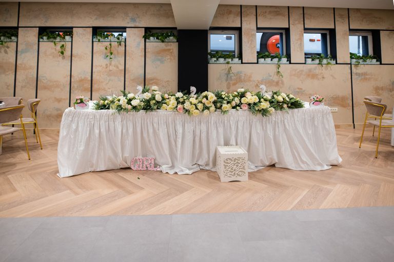 A white table with flowers and flowers on it at sala de evenimente Epic Harmony.