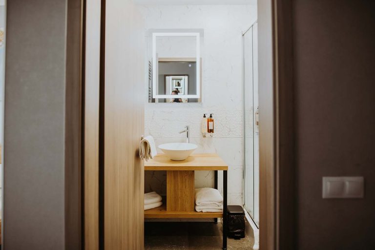 A hotel bathroom with a sink and a mirror.