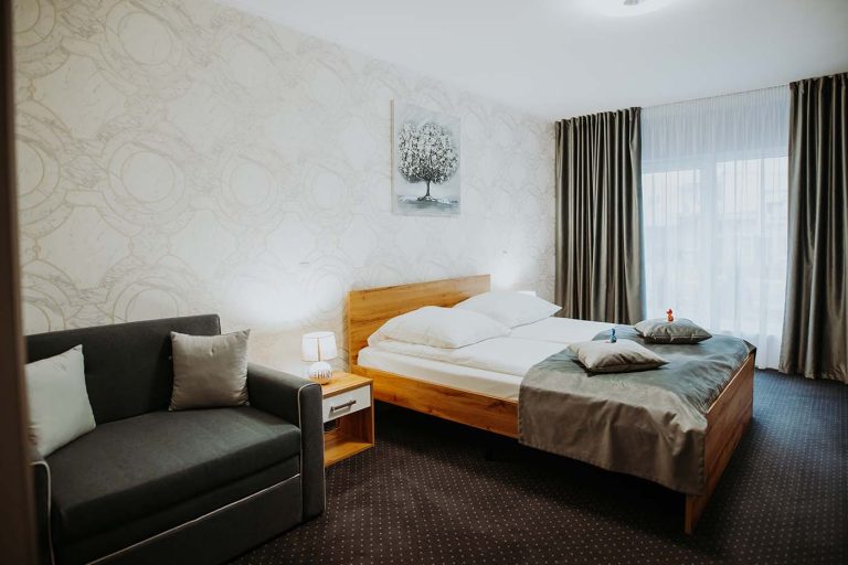 Un cameră de cazare în Sibiu, cu un pat și un canapea.