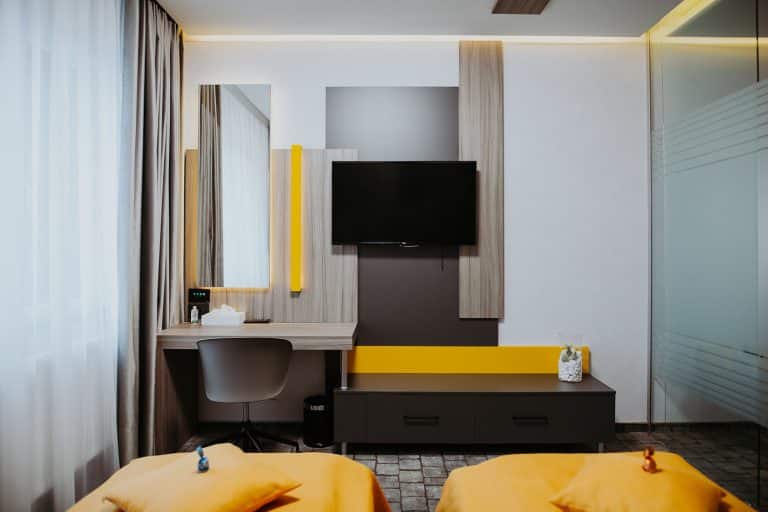 A Cisnadie hotel room with a yellow bed and a TV.