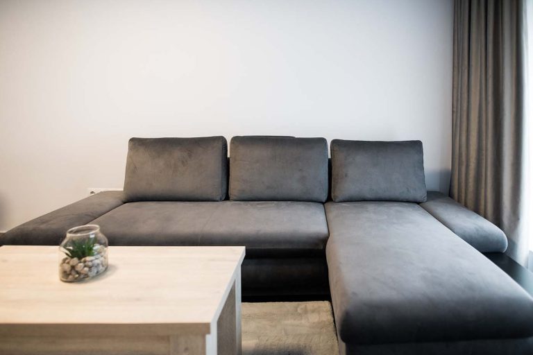 A hotel room in Sibiu with a grey couch and a coffee table.