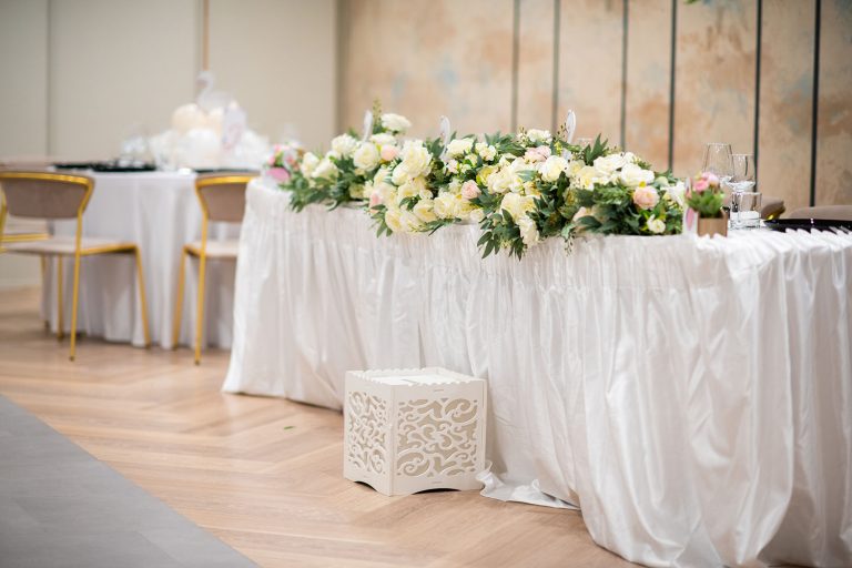 A white table with flowers on it in an Epic Harmony event venue.